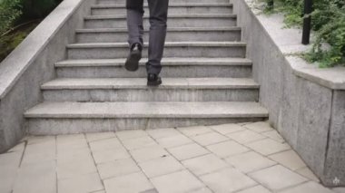 Dışarıdaki merdivenlerde yürüyen bir iş adamı. Kırpılmış. İş, insanların kavramı. Gerçek zamanlı konsept