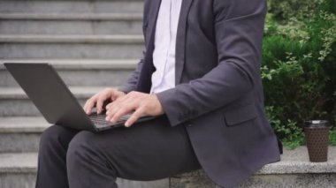 Takım elbiseli bir adam dizüstü bilgisayarını kapatırken internette işini bitiriyor. Kırpılmış. İş, iletişim, teknoloji konsepti. Gerçek zamanlı konsept