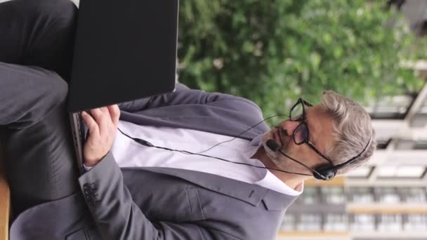 Volwassen Zakenman Met Behulp Van Een Headset Tijdens Het Typen — Stockvideo