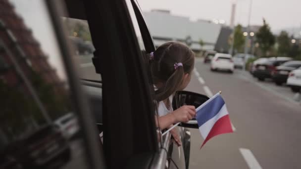 Mała Dziewczynka Ciesząca Się Podróżą Trzymając Flagę Francji Patrząc Przez — Wideo stockowe