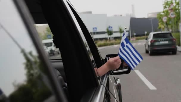 男孩在城市开车旅行时举着希腊国旗 生活方式的概念 慢动作 — 图库视频影像
