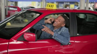 Arabada akıllı telefonla konuşurken el sallayan mutlu Afrikalı Amerikalı taksi şoförü. Servis arabası konsepti. Yavaş çekim