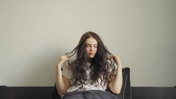 笑顔の若い女性は 寝室で朝起きて 伸びている スローモーション ライフスタイルコンセプト — ストック動画