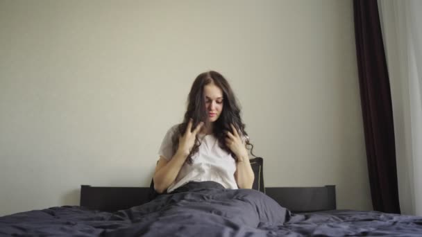 Mulher Tocando Cabelo Olhando Pela Janela Sentada Cama Casa Movimento — Vídeo de Stock