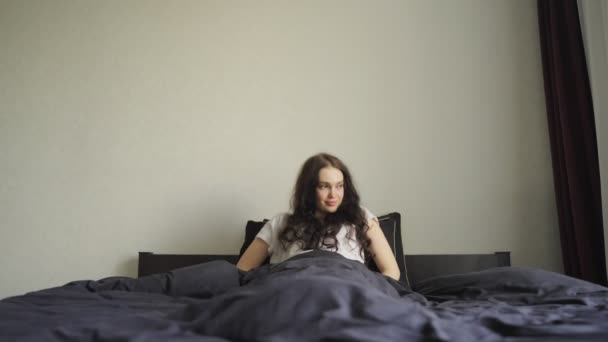 年轻妇女在家里醒来后坐在床上 慢动作生活方式概念 — 图库视频影像