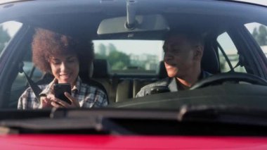 Kadın seyahat sırasında cep telefonu kullanırken, erkek sürücü arabada kahve içiyor. Yaşam tarzı, ilişki, ulaşım, insanlar, seyahat kavramı. Yavaş çekim