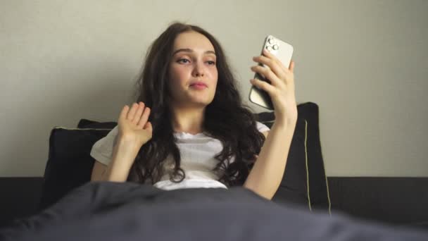 Güzel Bir Bayan Video Görüşmesiyle Konuşurken Akıllı Telefon Kullanıyor Yatak — Stok video