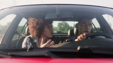 Genç Afro-Amerikan erkek ve kadın arabada seyahat ediyorlar. Yaşam tarzı, ilişki, ulaşım, seyahat, insan konsepti. Yavaş çekim