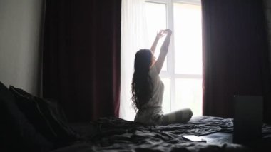 Mutlu kadın sabah, dulun yanında yatağında uzanırken esneme hareketleri yapıyor. Ağır çekim. Yaşam tarzı kavramı