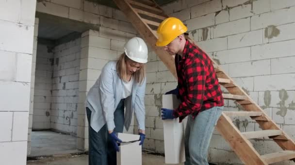 Pracownica Budowlana Uśmiechnięta Podczas Podnoszenia Pękniętego Bloku Betonowego Pod Nadzorem — Wideo stockowe