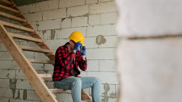 Müder Bauarbeiter Sitzt Auf Einer Treppe Vor Einer Ziegelmauer Und — Stockvideo