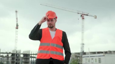 Korumalı yelek giyen profesyonel bir adamın portresi iş yerinde çalışmak için sıkı bir şapka takıyor. Yavaş çekim