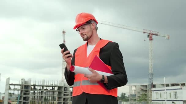 Portret Profesjonalnego Budowniczego Kasku Ochronnym Kamizelce Okularach Plandeką Smartfonem Czat — Wideo stockowe