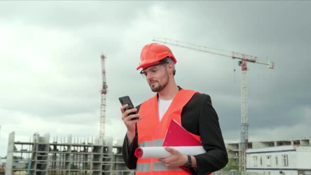 Professionele Voorman Beschermende Helm Vest Bril Met Blauwdruk Smartphone Chatten — Stockvideo