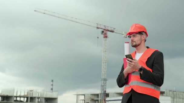 Professionele Supervisor Beschermende Helm Vest Bril Met Blauwdruk Smartphone Chatten — Stockvideo