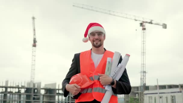 Pembangun Tersenyum Dalam Rompi Topi Natal Dan Kacamata Memegang Cetak — Stok Video