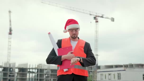 Professioneller Mann Weste Weihnachtsmütze Und Brille Mit Blaupausen Und Zeitkontrolle — Stockvideo