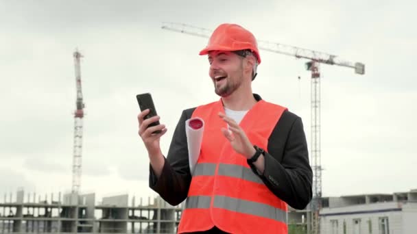 Profesjonalny Człowiek Kamizelce Ochronnej Pracujący Miejscu Trzymający Smartfona Dzwoniący Online — Wideo stockowe