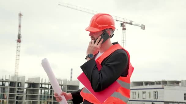 Byggare Skyddsväst Arbetar Plats Hålla Ritning Och Smartphone Prata Online — Stockvideo