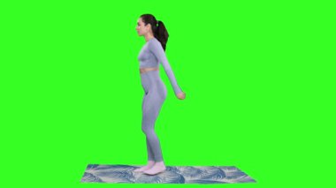 Yeşil izole edilmiş arka planda yoga minderinde dururken spor yapan genç bir kadın. Fitness, spor, sağlıklı, motivasyon kavramı