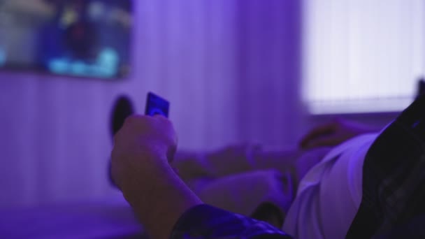 Jeune Homme Détendre Sur Canapé Maison Soir Regarder Télévision Tenant — Video