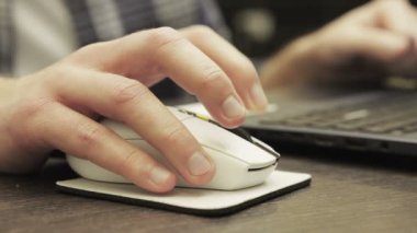 Erkek eller bilgisayar faresi ve klavye tuşlarına basıyor, adam masada oturuyor. Kapatın. Çevrimiçi çalışma, iş ve teknoloji konsepti. Yavaş çekim