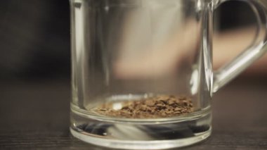 Taze sabah kahvesi. Anında cam bardağa düşen kahve parçaları. Kupayı masaya koy. Kırpılmış, kapat. Yavaş çekim