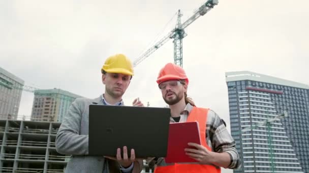 Bauleiter Hält Tragbaren Computer Der Hand Während Vorarbeiter Notizen Auf — Stockvideo