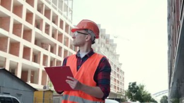 Çok katlı evi incelerken panoya bir şeyler yazan ciddi bir bina müfettişi. Yavaş çekim