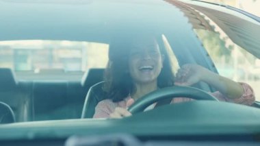 Park yerinde araba süren, müzik dinleyen ve dinlenen komik kadın sürücü. Yavaş çekim videosu