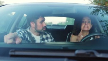 Araba kullanırken şok olmuş ve korkmuş genç bir çift, araba kazası geçirirken. Ulaşım, kaza, insan konsepti. Yavaş çekim