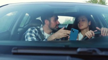 Adam, bir kadına telefonunda navigatörle güzergahı nasıl geçeceğini anlatıyor. Ulaşım, seyahat, teknoloji, insan konsepti. Yavaş çekim
