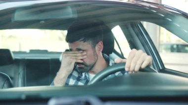 Yorgun bir adam şehirde bir arabada kendini stresli hissediyor. Ulaşım, insanlar, yaşam tarzı konsepti. Yavaş çekim