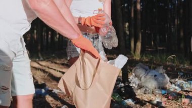 İnsanlar çevreye ve ekosisteme dost canlısı davranırken ormanda plastik şişe, çöp topluyorlar. Ekoloji ve geri dönüşüm konsepti. Yavaş çekim