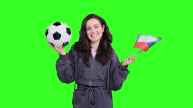 Çek Cumhuriyeti bayrağı önünde poz veren ve el sallayan genç ve mutlu bir bayan taraftar yeşil izole edilmiş bir futbol topunu tutarken