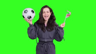 Gürcistan bayraklı mutlu kadın fanatik bir futbol topu tutarken yeşil izole edilmiş alanda kutlama ve çığlık atan gol