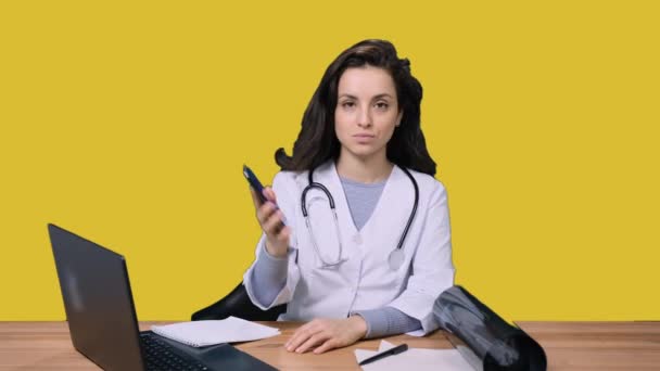 Ärztin Sitzt Schreibtisch Arbeitet Mit Laptop Und Handy Und Zeigt — Stockvideo