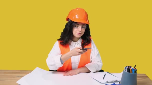 Jonge Vrouwelijke Architect Beschermende Helm Met Mobiele Telefoon Pratende Foto — Stockvideo
