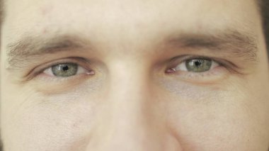 Erkek yüzü gülümserken kameraya bakıyor. İnsani duygular. Kırpılmış, kapat. Göz bakımı, vizyon kavramı. Yavaş çekim