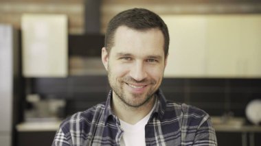 Kameraya poz veren, arka planda mutfak olan beyaz kadın pozu. Yaşam tarzı konsepti. Yavaş çekim