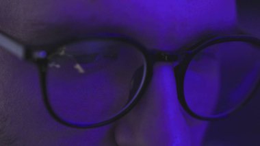 Gözlük takan, karanlıkta oturan, ekrana bakan, internetten DJ parti programı izleyen bir adam. Ağır çekim. Kapatın. Eğlence, eğlence ve festival konsepti