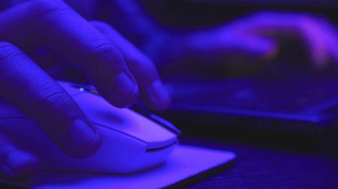 Adam geceleri internette dizüstü bilgisayarda çalışıyor, mesaj atıyor, bilgi arıyor, fareye tıklıyor. Kapatın. Çevrimiçi çalışma, iş ve teknoloji konsepti. Yavaş çekim