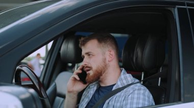 Telefona beyaz adam cevap veriyor, arabada cep telefonu kullanıyor. Ulaşım, teknoloji, seyahat konsepti. Yavaş çekim