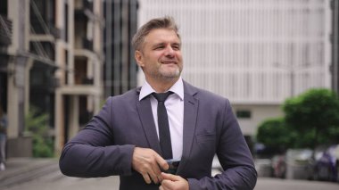 Sokakta dikilirken cep telefonuyla konuşan mutlu yetişkin adam. İş, insanlar, teknoloji kavramı. Yavaş çekim