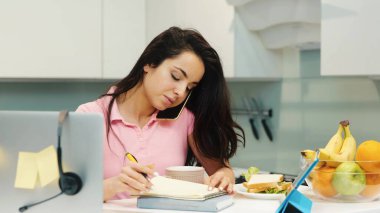 Karantina sırasında evde çalışan genç bir kadın. Aynı anda hem telefonda konuşan hem de not alan bir kız. Çoklu işlevsel çoklu görev sahibi kişi ve çalışan