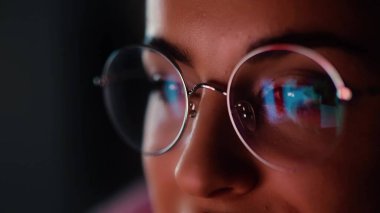 Karantina sırasında genç bir kadın evdeymiş. Yansımasıyla ekrandaki kızların yüzünü kapat. Gece geç saatlerde film ya da video izliyorum.