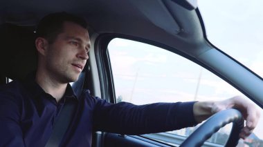 Arabanın içindeki genç adam. İşadamı tek başına nakliye aracını dikkatli kullanıyor. Öne ve yana bak. Arabadaki yakışıklı sürücü.