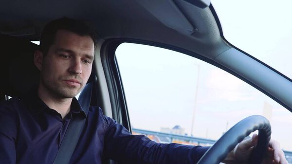 Молодой человек внутри машины. Водитель сидит на переднем сиденье и едет один. Сконцентрированный и серьезный бизнесмен едет осторожно. Взгляд в будущее
