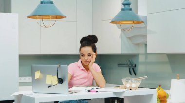 Karantina sırasında evde çalışan genç bir kadın. Dizüstü bilgisayar kullanıp notlar alan çok işlevli bir kız. Yoğun bir çalışma gününden ve pişirme sürecinden sonra. Akşam vakti.