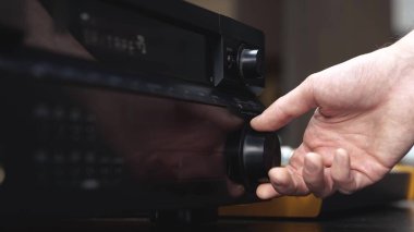 Ses kayıt stüdyosundaki genç adam. Erkek elinin müzik konsoluna ulaştığı ve sesi değiştirdiği görüntüyü kes